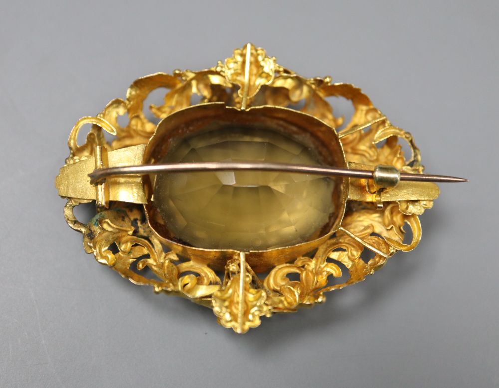 A Victorian pierced yellow metal and citrine set oval brooch, 47mm, gross 12.9 grams.